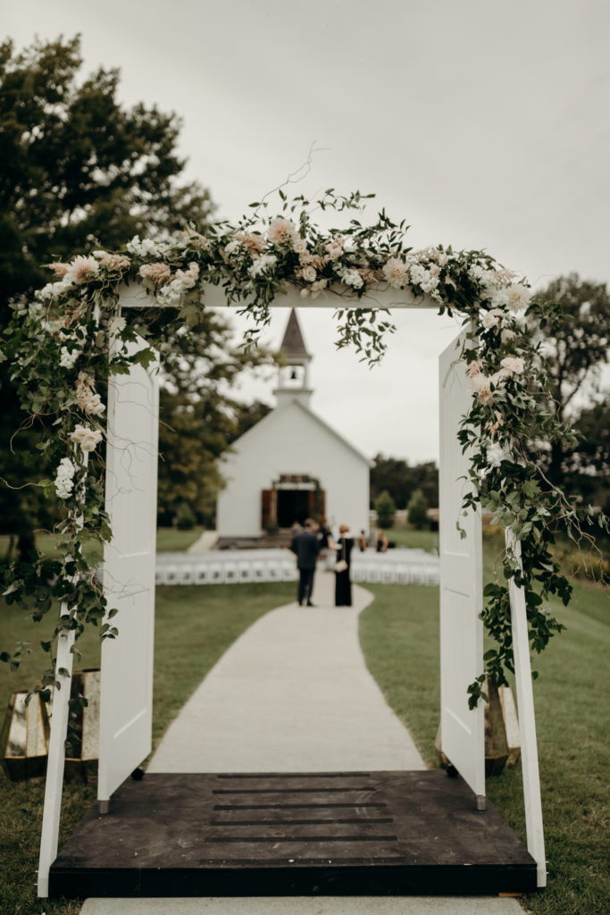 A wedding arch you can see people standing on the other side of. 