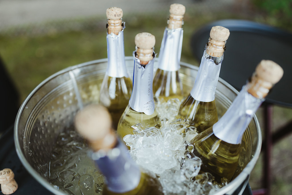 Champagne bottles nestled in ice in a large tin bucket.